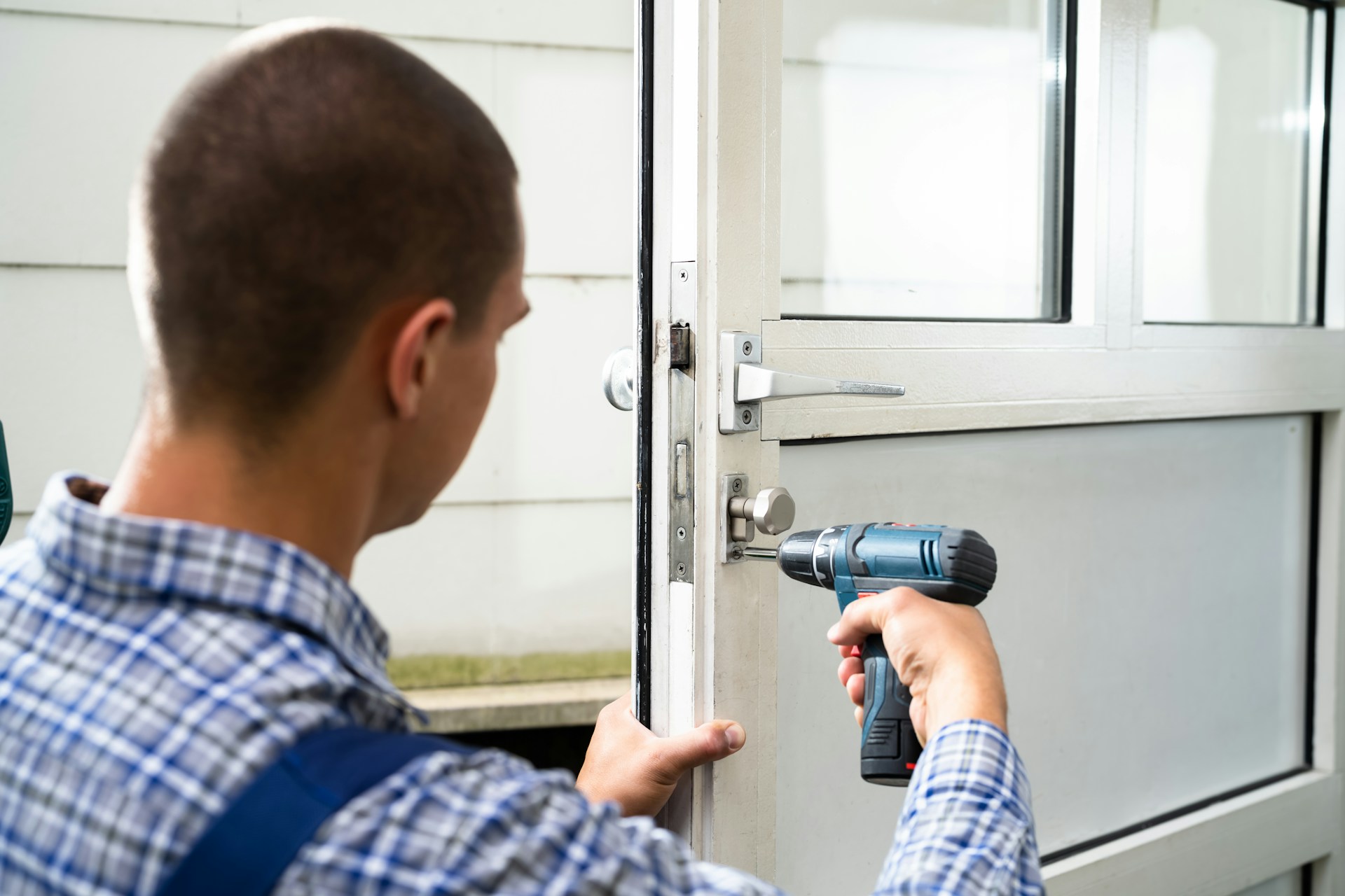 Professional locksmith working on a door lock with tools